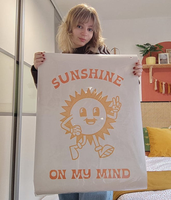 Image of the owner of Lauren Beth Designs holding a print saying' Sunshine on my mind'